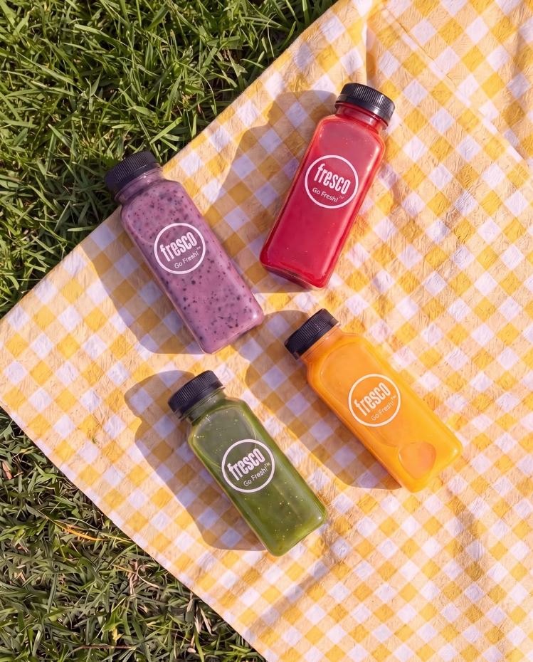 Fresco juice bottles on a picnic blanket